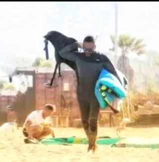 A group of people on the beach with surfboards